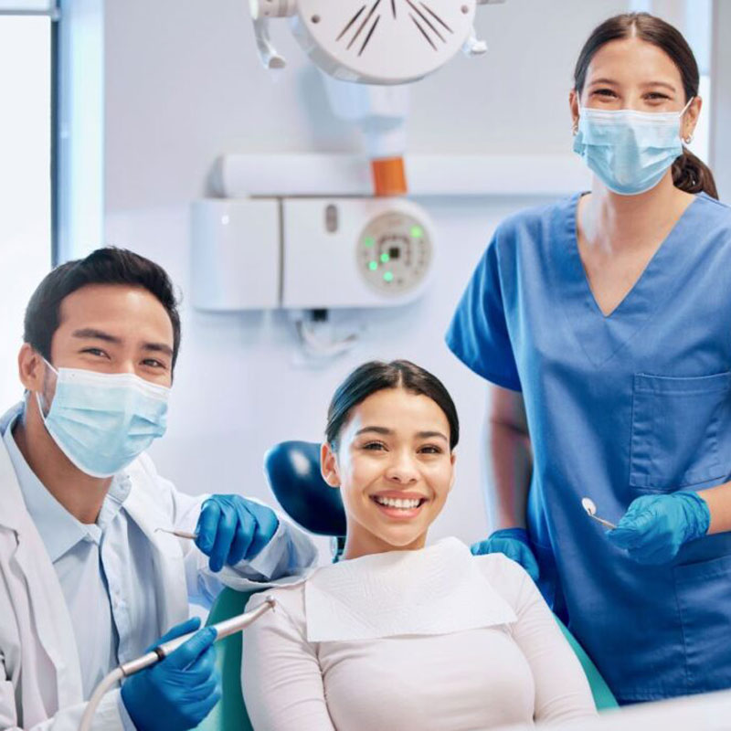 dentist with patient in dental chair smiling